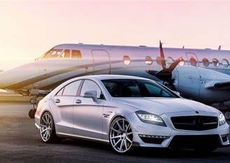 a mercedes cla parked in front of a plane