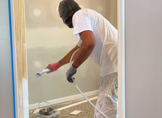 Professional Painter Spraying a Reinstalled Door with a Smooth, High-Quality Finish