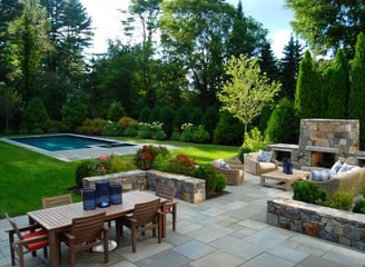 a patio with a table and chairs and a fireplace