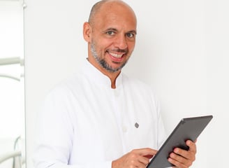 a man in a white shirt and a tablet computer