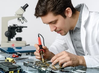 a man in a lab coat working on a circuit board