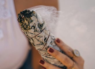 herbal smudge and a hand
