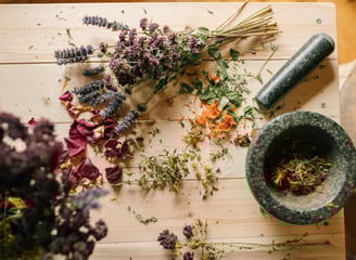 a mortar and herbs on the table