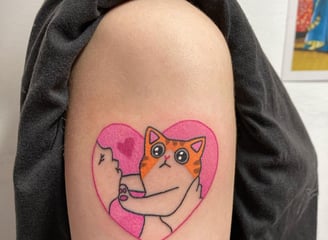 a cat with a heart shaped tattoo on the arm