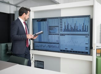 a man in a suit and tie is holding a tablet computer