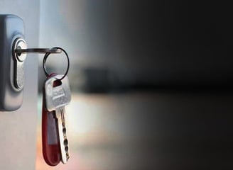 a key chain with keys on a door