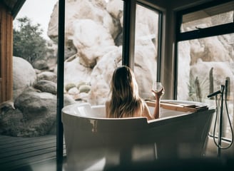 Frau in einer Badewanne mit einem Glas Wein in der Hand