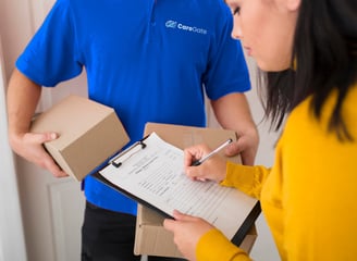 a man and woman holding boxes and a clipboard