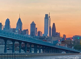 a bridge Ben Franklin Bridge spanning the width of a city skyline Philadelphia city sunset