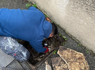 a man is sitting on the ground next to a trash can