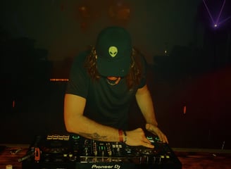 a man in a hat and a hat on a dj booth