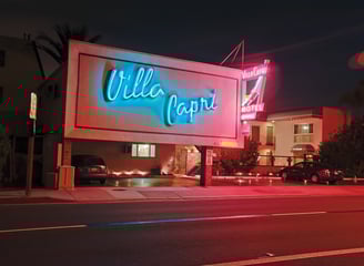 a hotel boarder with a neon sign that says villaggio