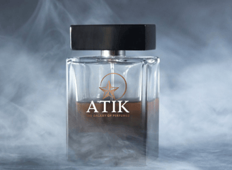 a bottle of atik perfume on a smokey background