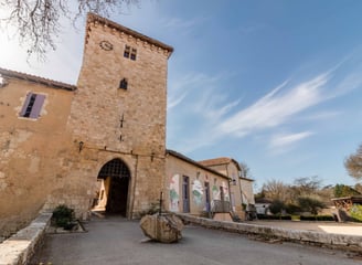 Entrée de la bastide de Sarrant sous un ciel bleu, mise en valeur du patrimoine gersois en photo