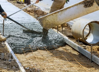 a man is pouring concrete into a concrete slab