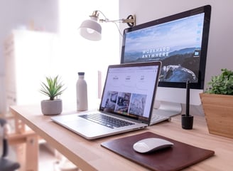 MacBook Pro on table beside white iMac and Magic Mouse