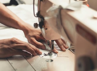 deux mains utilisent une machine à coudre