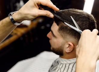 Client al frizeriei care este tuns de un specialist