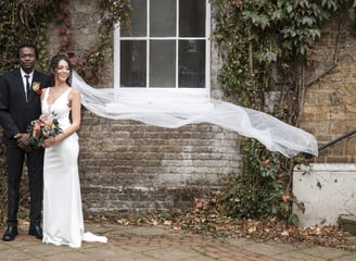 Hertfordshire Bride & Groom standing with the brides veil blowing in the wind