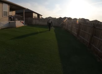 A person using a spray to keep grass free of pest