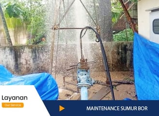 a man is spraying water from a hose in a yard