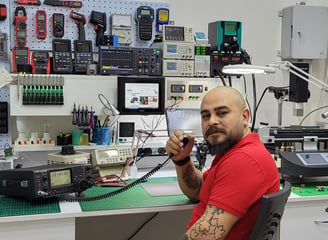 a man sitting at a desk with a laptop and a cell phone