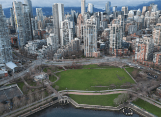 a cityscape of a large city with a green field