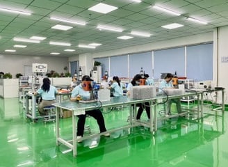 a group of people working on a table in a factory