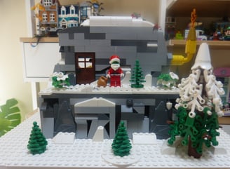 cabaña de el Grinch de LEGO. Cueva de rocas grises y blancas. Arboles de navidad de LEGO. 