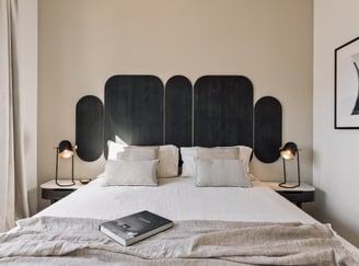 Vibrant bold black wood headboard design in a bedroom with neutral colours and natural materials