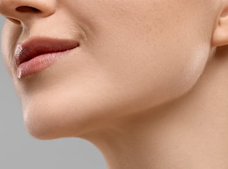 Close-up of a woman's lower face, showing a defined jawline and neck.