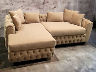 Beige tufted sectional with plush cushions and rolled arms, custom-designed by Solo Home Decor.