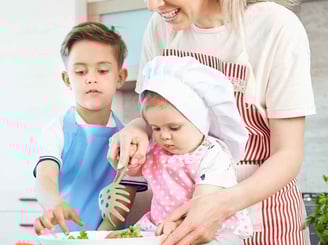 a woman and two children are cooking in a kitchen