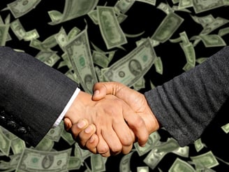 two people shaking hands with money bills and money