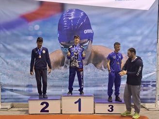 a man standing on a podium with a medal