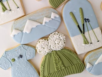 Cookies of onesies, hats, skis, and mountains for a baby shower