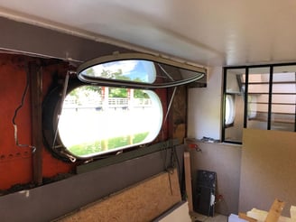 Sabord oblong ouvert sur une péniche