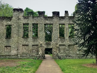 a large historical stone building with a walkway
