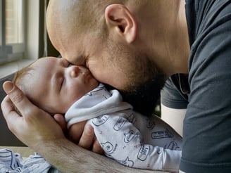 a man is kissing a baby