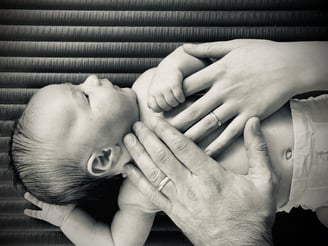 a couple holding hands with their baby