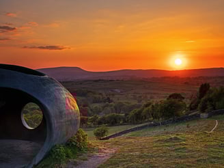 a sunset over a hill with a large circular shape: the wycoller atomd object
