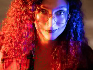 a woman with glasses in red and blue light