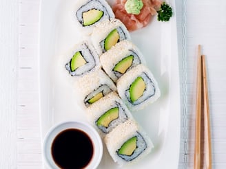 a plate of sushi rolls and chopsticks