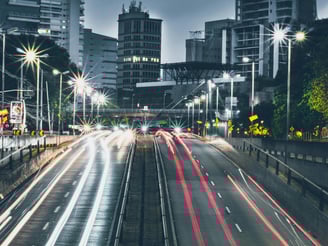 a city street scene with a train on the tracks