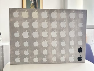 foto da arte contemporânea composta de uma tela de 70x50 cm pintada em cinza claro coberta por 48 adesivos da apple.