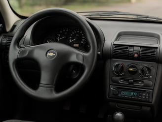 Interior de um Chevrolet Corsa com painel simples e volante original bem conservado. Ask Cha