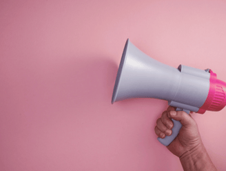 Hand holding a megaphone for blog post promotion | Amplify blog content and increase audience reach