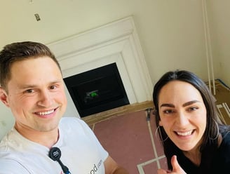 Happy customer posing with Alex, Vision Flooring. On the background there is fireplace mantle.