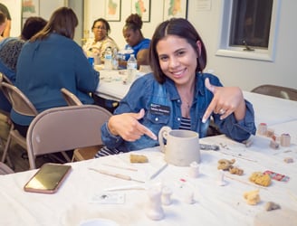 An individual posing with the slab mug she built.