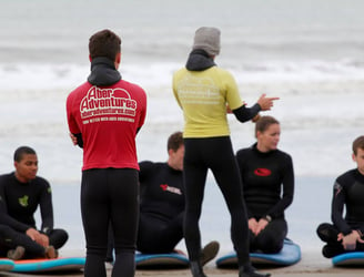 Two surf instructors giving a surf lesson safety brief